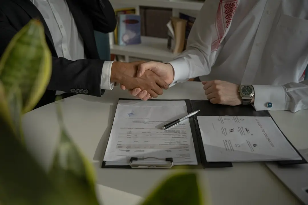 Local SEO Services Deal Success two people shaking hands over a piece of paper after closing a deal